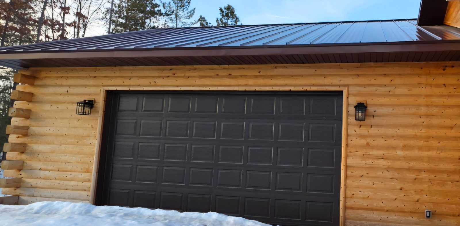 Outdoor sconce lighting on a log cabin garage